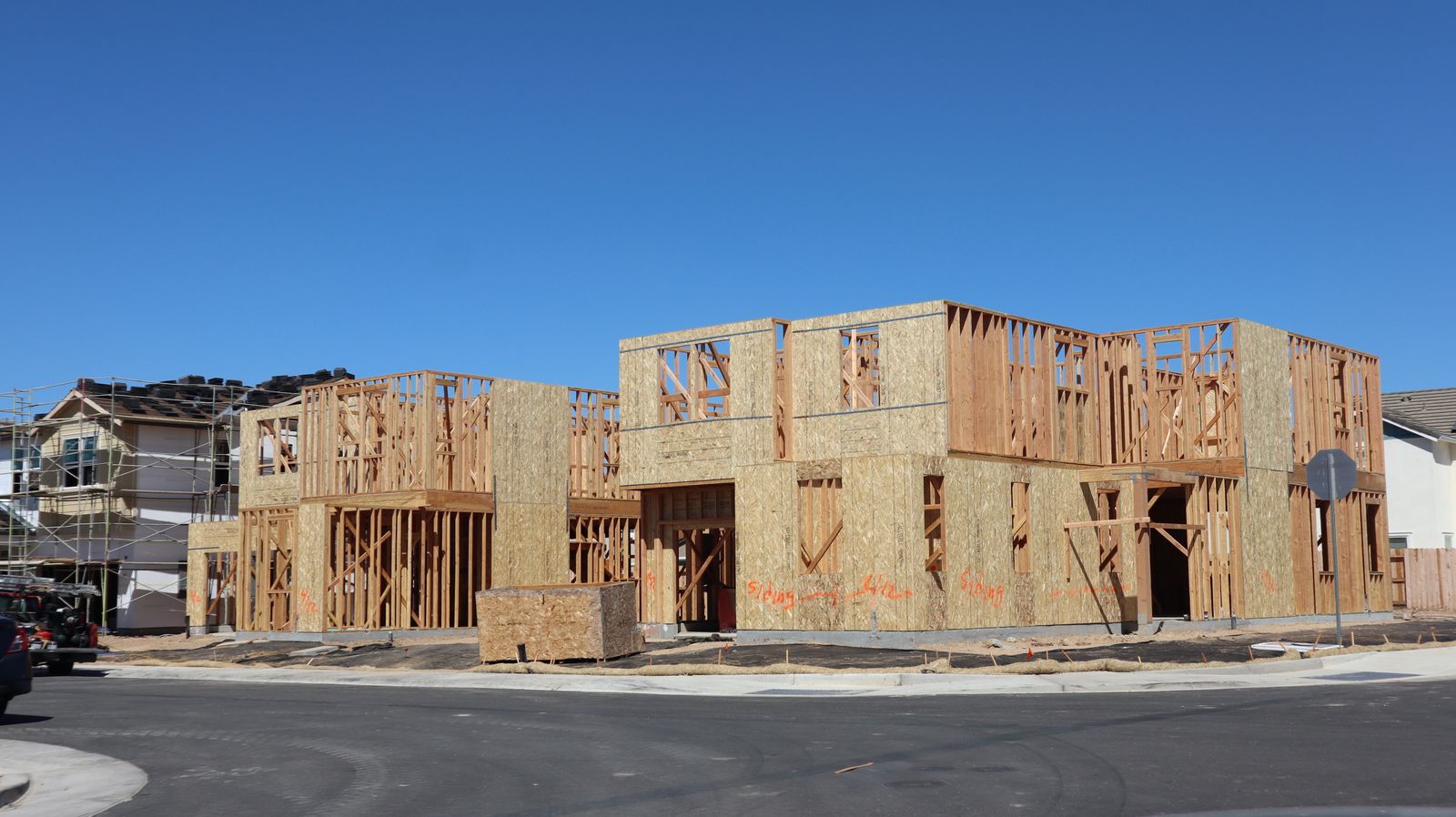 Timber-framed houses under construction on a residential lot