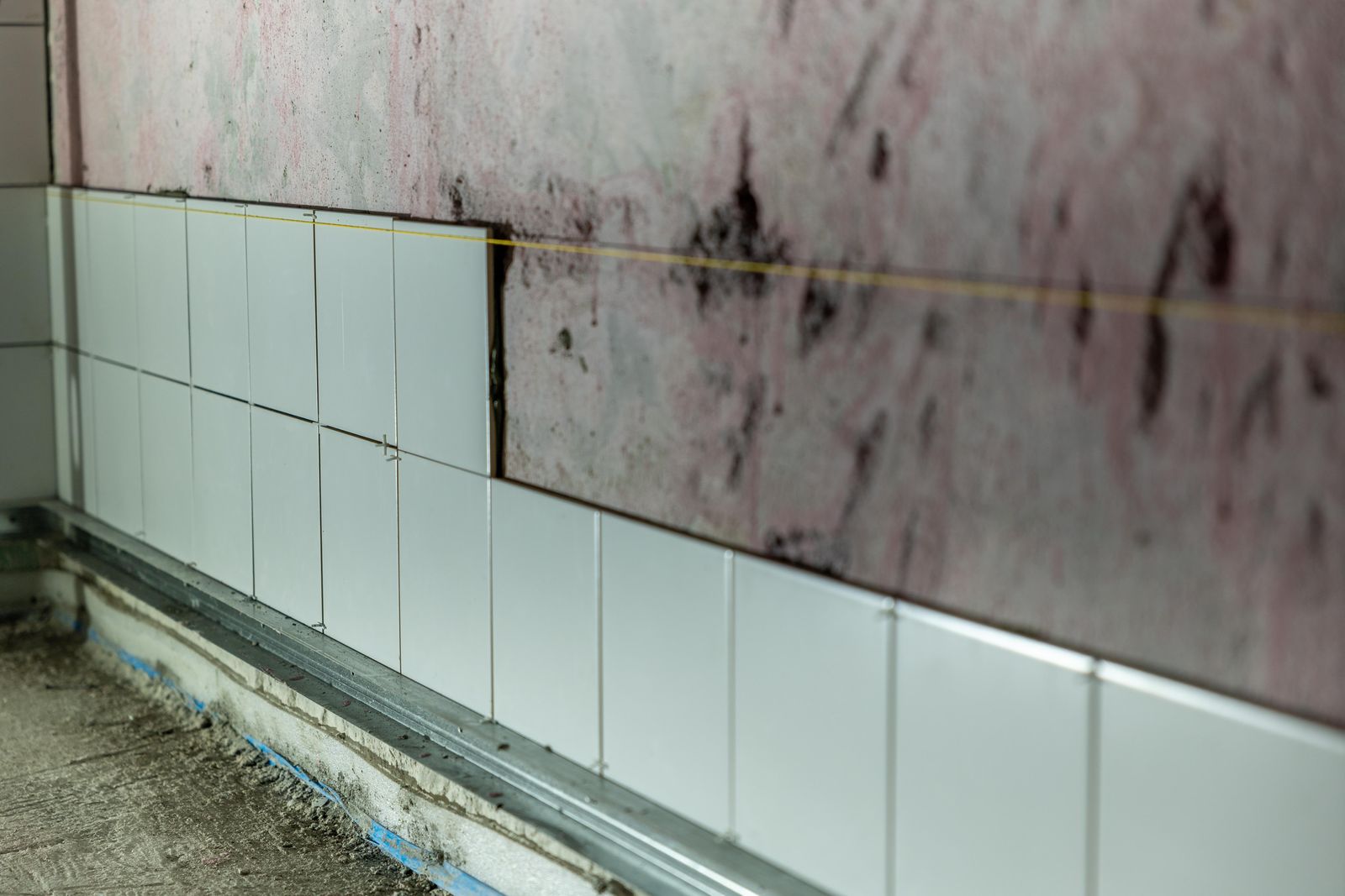 Partially tiled bathroom wall in the middle of a renovation