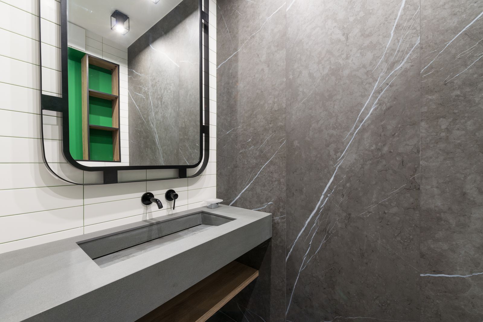 Modern bathroom with a lit mirror mounted above a white washstand