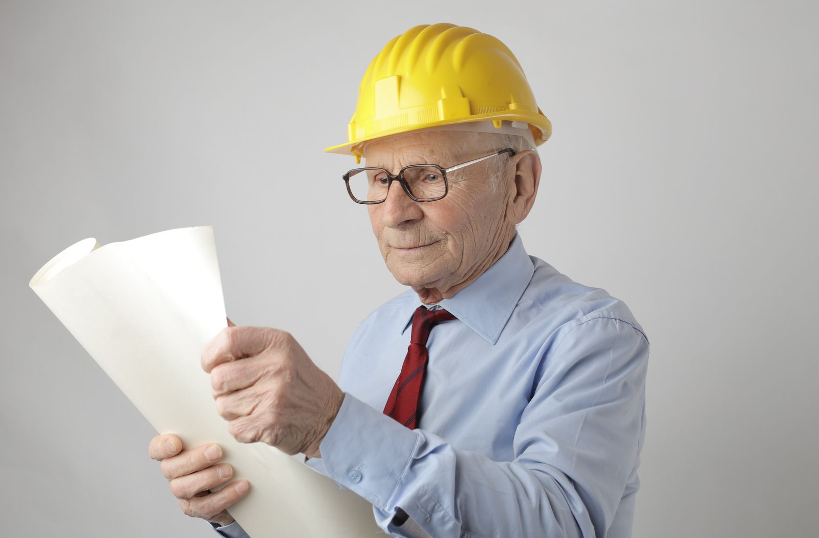 Engineer studying a printed blueprint at a work table