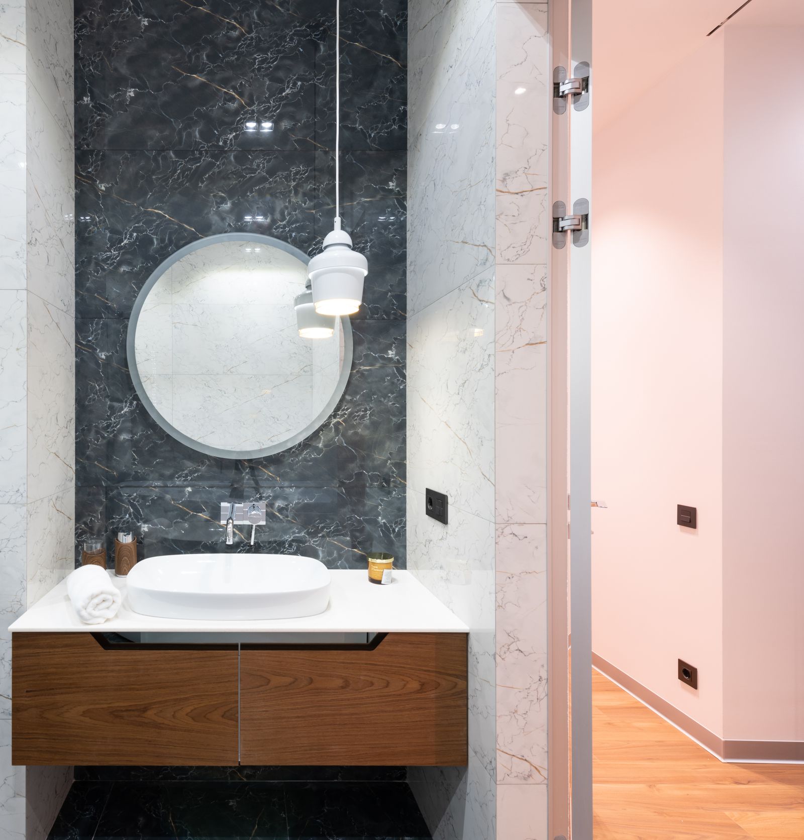 Contemporary bathroom with a round mirror above a single sink