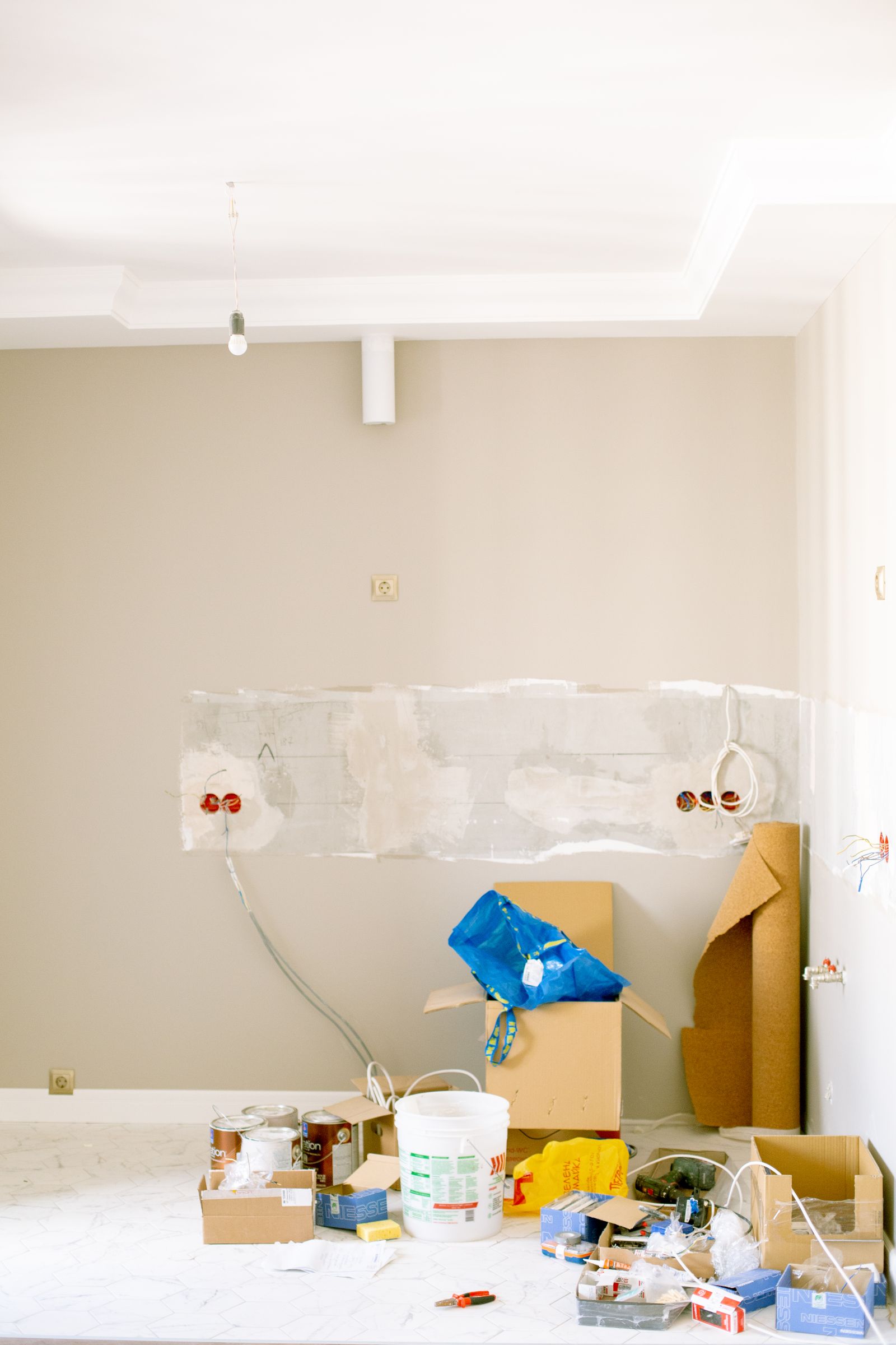 Room being renovated with unfinished surfaces and tools on the floor