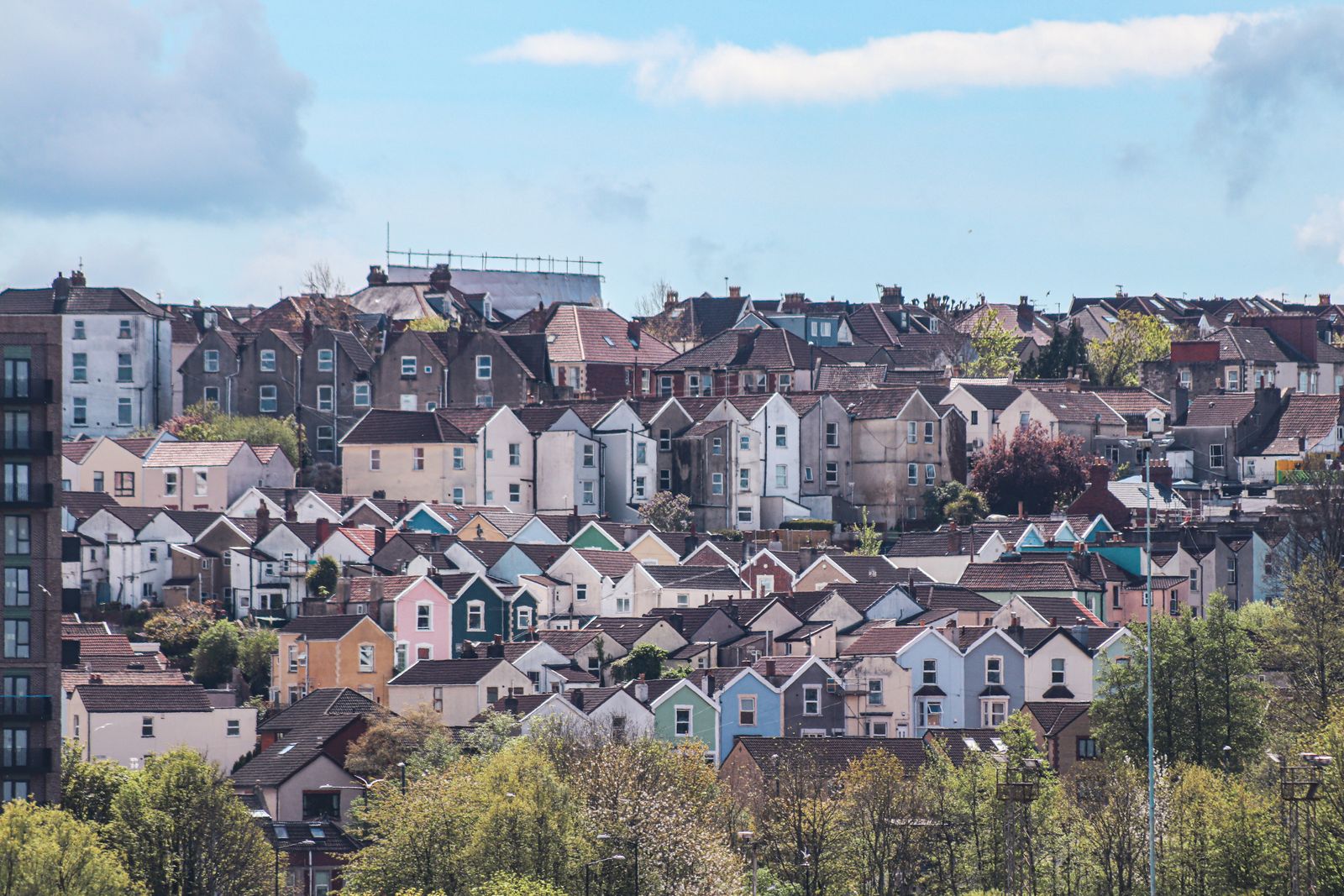 Rows of houses stepping down a steep hillside above a city