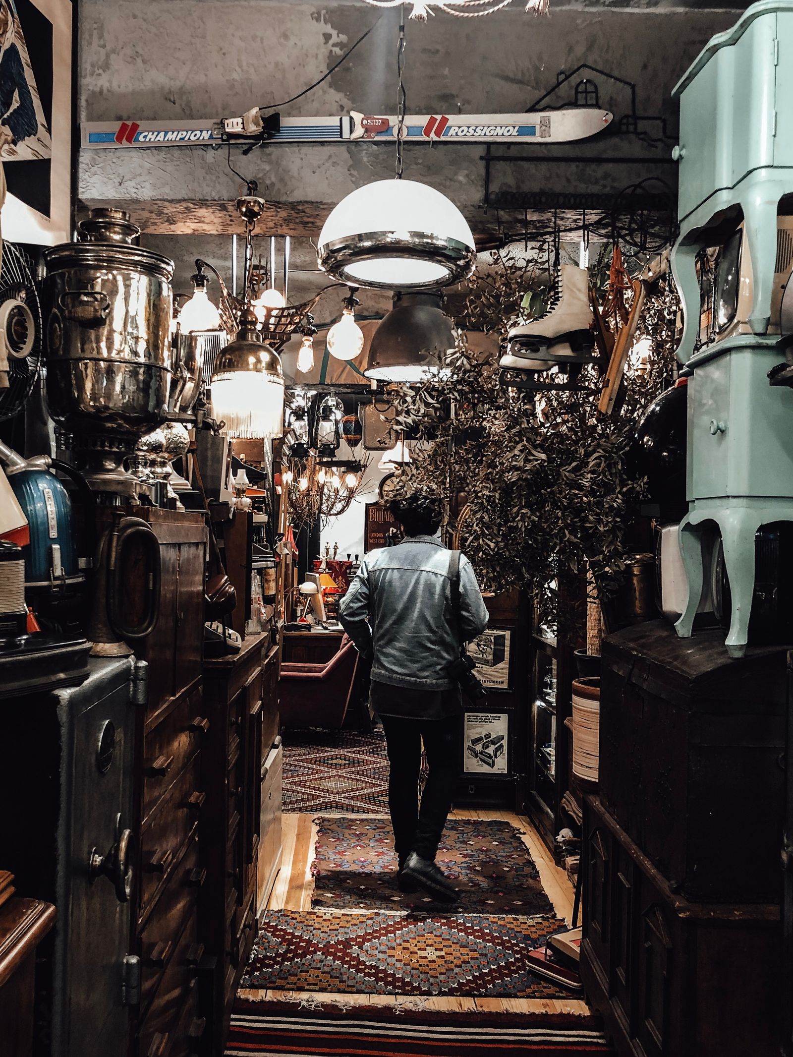 Person browsing shelves of vintage objects inside a second-hand shop