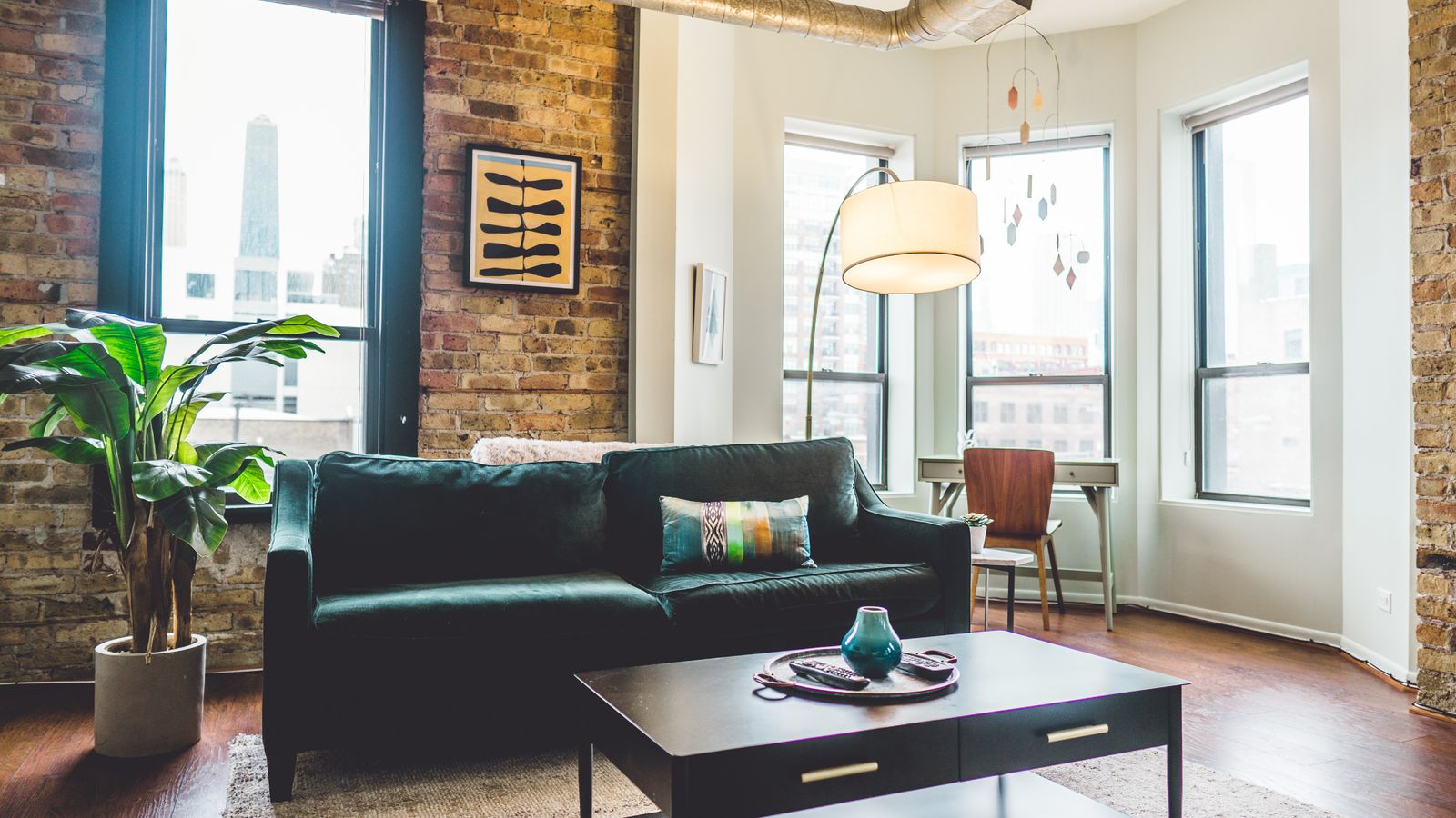 Green two-seat sofa placed against a plain wall